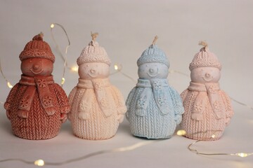 Snowman-Shaped Candles in Knitted Outfits with Christmas Balls and Garland — Cozy Holiday Decor...