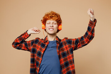 Young redhead man he wear red shirt blue t-shirt casual clothes listen to music in headphones raise...