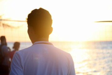 Silhouette of a man gazing at the sunset over the ocean, great for travel, lifestyle, and...