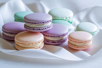 Obraz premium Colorful macarons arranged on a white fabric. The macarons are in pastel shades of purple, green, and pink, showcasing a variety of flavors and textures.