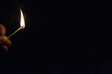 Cerilla encendida. Cerilla predida. Hacer fuego.  Fuego en la oscuridad.