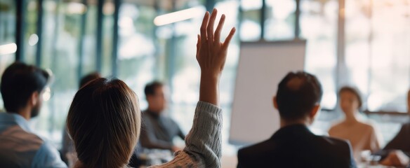 The engaged audience member raises hand during a collaborative business meeting.