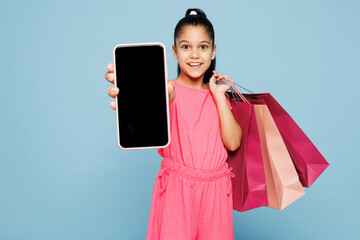 Little kid girl 9-10 years old wears pink clothes hold paper package bags after shopping use blank...