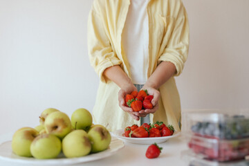 Caucasian woman preparing homemade fruit leather, slicing fresh fruit in her kitchen for a healthy...