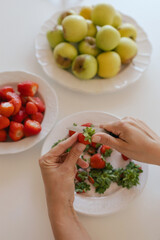 Caucasian woman preparing homemade fruit leather, slicing fresh fruit in her kitchen for a healthy snack. Part of a series on organic treats and natural living