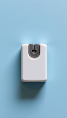 A white compact device with a gray metallic insert sits centered on a plain light blue background