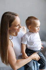 Happy maternity leave time. Beautiful young mother holding adorable little child in her arms and smiling, free space