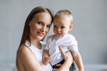 Happy maternity leave time. Beautiful young mother holding adorable little child in her arms and smiling, free space