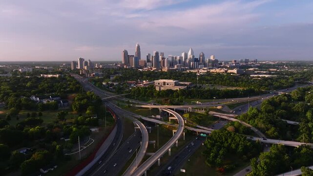 Aerial view of Charlotte's skyline juxtaposed with the intricate highway system cutting through the lush greenery, creating a vibrant urban landscape, Charlotte, North Carolina, United States.