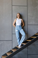 Young woman standing on a home stairs