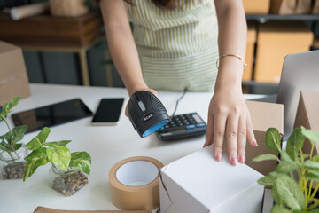Asian Women Entrepreneurs in SME Using Laptops to Process Online Orders and Manage Parcel Deliveries.
