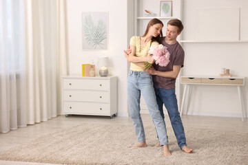 Young couple dancing together at home. Space for text