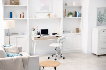 Desk with modern laptop, coffee and stationery in home office