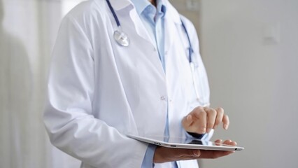 Doctor woman wearing lab coat and stethoscope using tablet computer in hospital. Medicine and...
