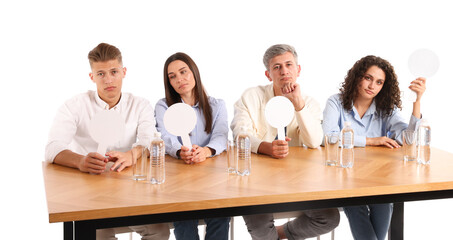 Panel of judges with blank score signs at table on white background