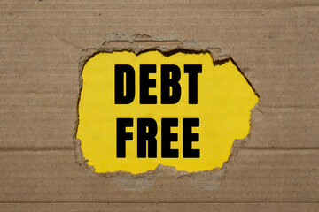 Debt free message written on ripped torn cardboard paper on yellow background. Conceptual debt free...
