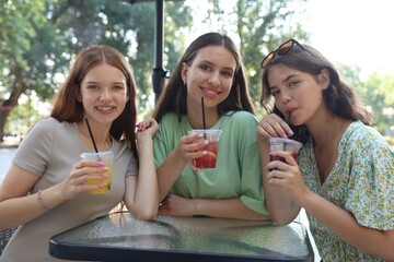 Friends enjoying refreshing drinks in outdoor cafe