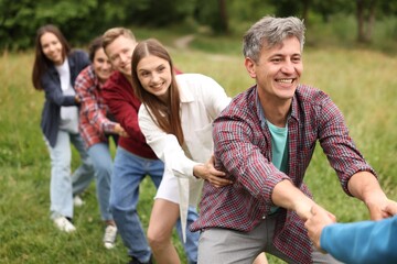 Fototapeta premium Team building. Group of happy people holding hands outdoors