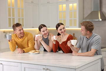 Friends with coffee laughing in kitchen. Positive emotion