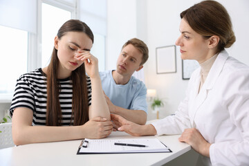 In vitro fertilization (IVF). Upset couple having appointment with doctor in reproductive clinic