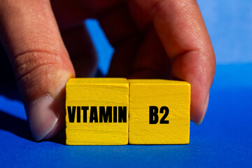 Vitamin B2 message written on yellow wooden cubes on blue background. Conceptual Vitamin B2 symbol....