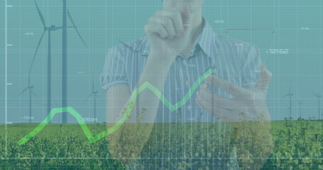 Professional in striped shirt holding smartphone and using line graph in wind turbine field, grid