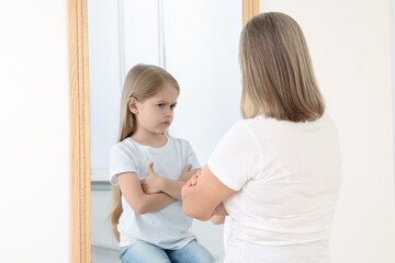 Senior woman seeing herself as child in mirror. Conceptual collage about past and future, flow of...