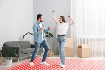 Couple dancing on warm floor at home, double exposure with underfloor heating system
