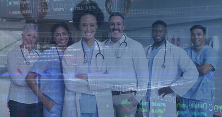 Standing team wearing lab coats, blue scrubs, stethoscopes in hospital corridor, with data overlay