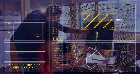 Coworkers in business attire typing on laptops and pointing at map in office, with data overlays