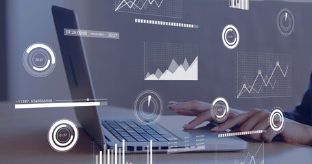 Typing office worker wearing dark top analyzing data on laptop at office desk, with graph overlays