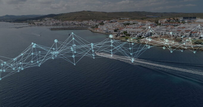 Floating digital network overlay tracing nodes over hillside town and sea, with motorboat wakes