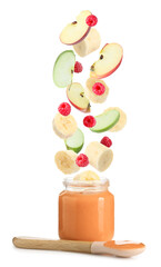 Baby food. Raspberries, apple and banana slices falling into jar of puree on white background
