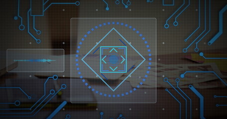 Hovering interface panel above wooden desk in office, showing diamond reticle and waveform