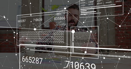 Typing bearded developer in checkered flannel shirt coding on laptop at office, with data overlays