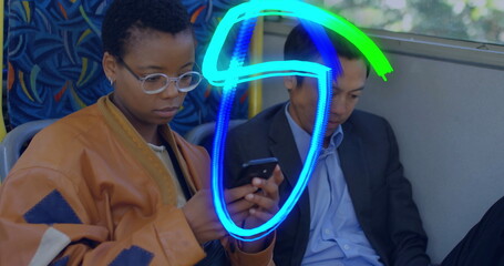 Two commuters wearing rust jacket and suit scrolling smartphones on bus, patterned seats and rail
