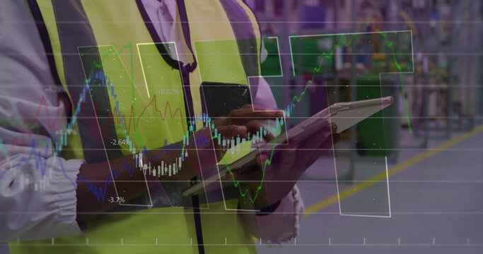 Monitoring warehouse supervisor in yellow vest using tablet and phone in aisle, with chart overlays