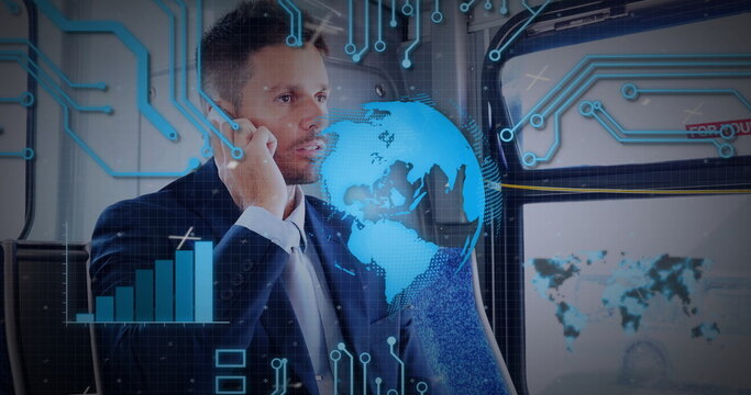 Talking mid-adult businessman holding smartphone in train carriage, with digital globe overlay - Powered by Adobe