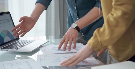 Business people, professionals analyzing financial charts and data on a desk while standing and using laptop computer in office