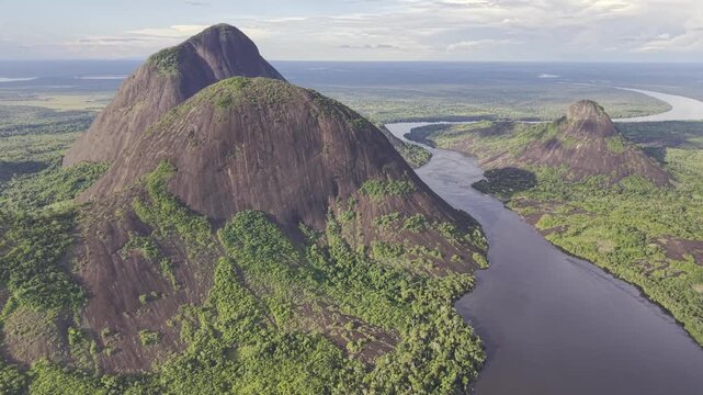 Aerial view of the striking Cerros de Mavicure, where dark waters cut through the landscape, contrasting with the lush green vegetation, Cerros Mavicure, Colombia.
