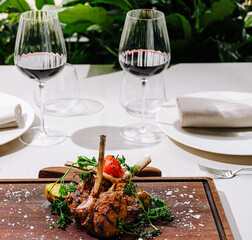 Exquisite lamb dish served with red wine and elegant table setting