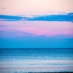 Obraz premium Serene seascape at twilight, pastel hues dominate the sky and water