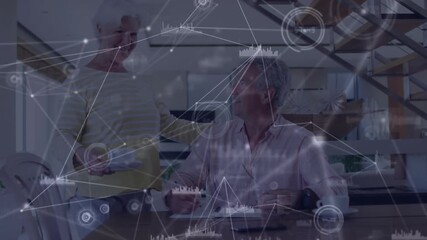 Senior man writing document initiating data charts overlay, woman placing coffee fueling tech work - Powered by Adobe