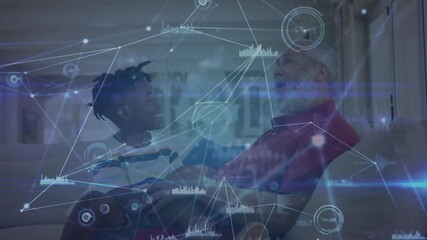 Grandson giving VR headset to grandfather pressing controller making swirling tech charts - Powered by Adobe