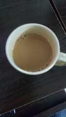 Cup of Milk Tea on Wooden Table, Warm Beverage, Cozy Morning Drink.
