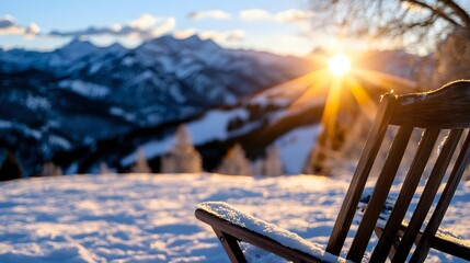 Wooden chair covered in snow overlooking majestic mountain landscape at sunset with dramatic sunburst through clouds, winter outdoor relaxation scene.
