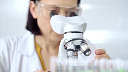 Woman scientist using microscope in laboratory. Microbiology science concept