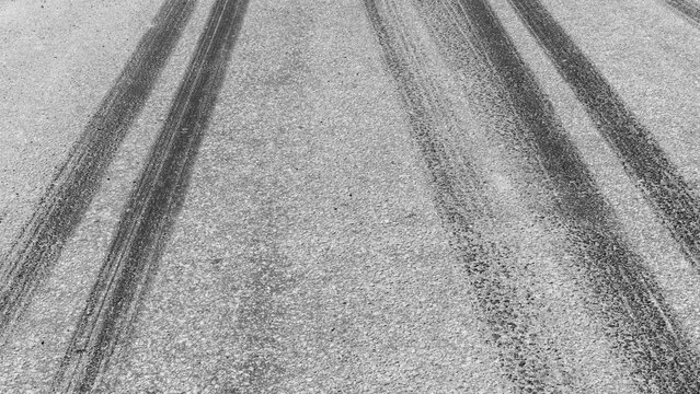Black tire marks on road, Black rubber tire marks and tread marks, Tire trace track wheels texture and background, Auto tire tread grunge, Car wheel tyre tread track black tyre print, Aerial view.