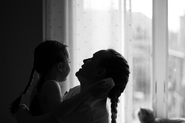 Little girl hugging mother affectionately