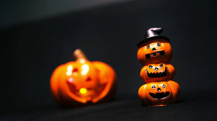 Halloween tower orange pumpkin with candle on black background